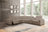 Gray sectional sofa in a living room with large windows and decorative wall art.