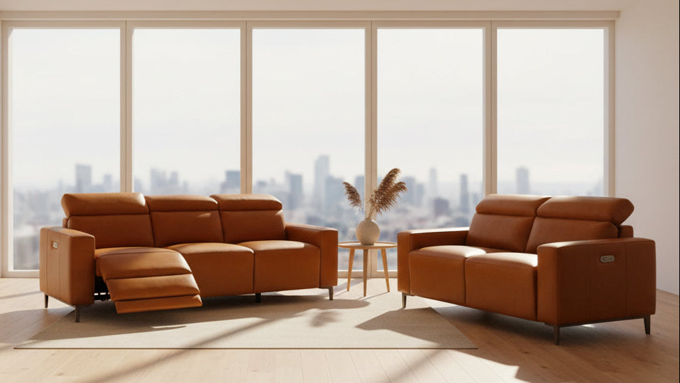 A brown leather reclining sofa shown with the footrest extended, alongside a matching brown leather two-seater loveseat on a plain white background.