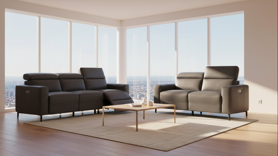 A dark gray leather reclining sofa shown with the chaise extended, alongside a matching two-seat sofa on a plain white background.